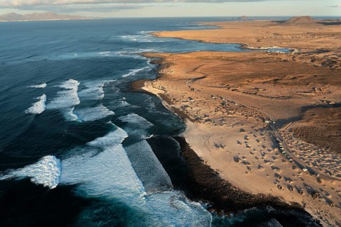 High-angle shot capturing the unique wave patterns and the sandy shore of Popcorn Beach in