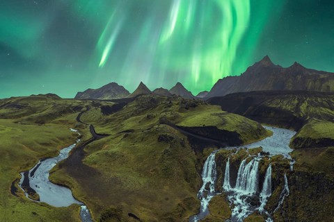 The breathtaking Northern Lights illuminate Iceland's dramatic terrain, featuring stunning