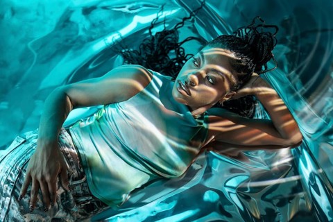 A futuristic African young woman immersed in a metaverse scene, surrounded by vibrant, reflective