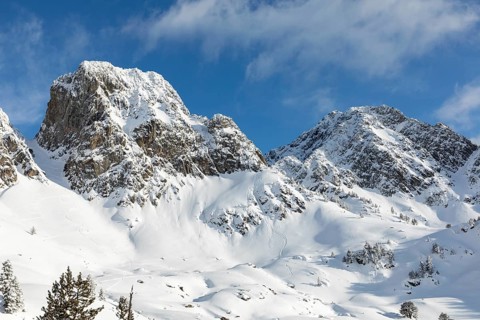 A breathtaking view of snow-laden mountains under a clear blue sky, perfect for adventurous winter