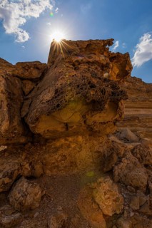 The morning sun shines over a reddened rock, Huqf stone desert, Arabian Peninsula, Sultanate of