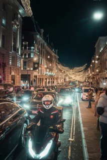 Nocturnal street scene with traffic, motorbikes and bright lighting, New Year's Eve London, Great