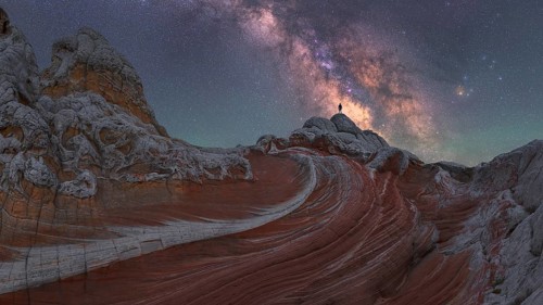 A stunning nightscape of the Milky Way galaxy arching over the unique rock formations at White