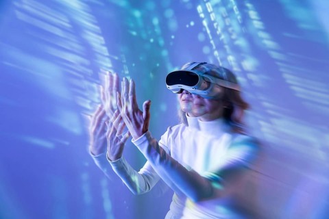 An elderly Asian woman engages with the digital world using a VR headset, illustrating the blend of