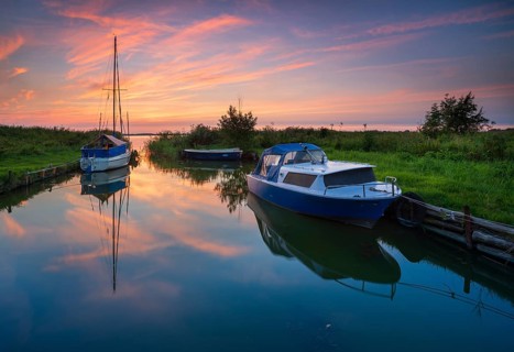 Sunset on the Achterwasser, boats moored in a small natural harbor, near Zinnowitz, Usedom island,