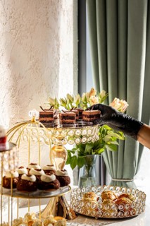 A luxurious dessert spread featuring various cakes and pastries displayed on elegant, crystal