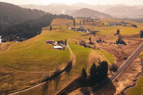 Wide landscape with fields, hills and a village in sunlight, Oberreute, Allgäu, Germany