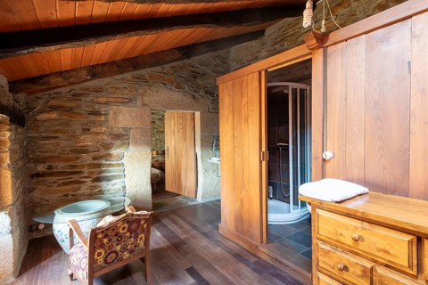 Picture of a charming rustic room inside a country house located in Lugo, Spain, featuring a stone