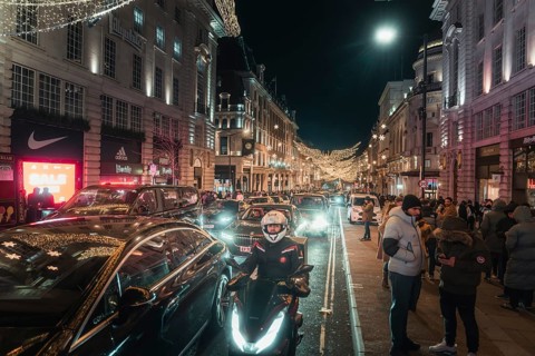 Busy street at night with traffic and brightly lit buildings and roads, New Year's Eve London,