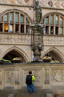 Historic market square with Roland fountain in front of the town hall and a person of small
