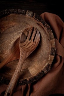 Wooden plate, handmade, with salad spoons, top view, on a wooden table, no people