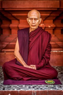 YANGON, MYANMAR, JANUARY 3, 2014: Ascetic Buddhist monk meditating in Shwedagon Paya pagoda