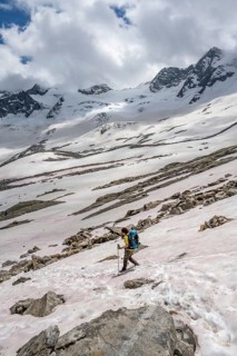 Mountaineer on a snowfield, descent from the summit of Schönbichler Horn, view of snow-covered and