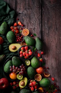 A vibrant assortment of fresh fruits and vegetables, including avocados, strawberries, grapes, and