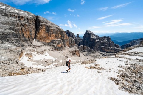 Mountaineers in a snowfield on the Sella della Tosa, mountain landscape with steep cliffs, Brenta