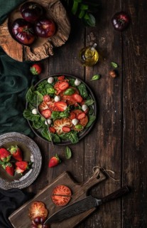 Healthy tomato and strawberry salad on a wooden rustic table