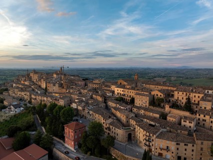 Aerial view of the historic town of Treia in Italy at sunset. The ancient architecture and warm
