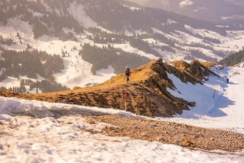 Landscape with snow-covered mountains and a narrow hiking trail that snakes through the winter