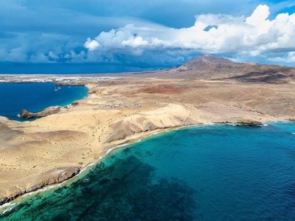 Coast with Playa Caleta del Congrio beach and blue sea, arid landscape of Los Ajaches Natural Park,