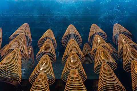 Numerous large, spiral incense coils hanging in a Taoist and Chinese Buddhist temple in Macau,