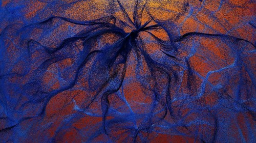 An intricate design featuring swirling particles in shades of blue and orange This abstract