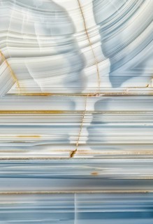 A macro photograph showcasing the striking linear patterns and mineral details inside a Whitcomb