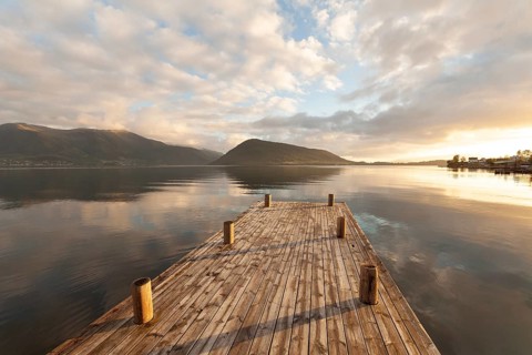 Golden hour light over the harbor and mountains. Summer sunset, Rosendal Port, Vestland, Norway