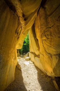 Incidental sun illuminates the passage (Chambre du Roi) through the high rocks, hike through the
