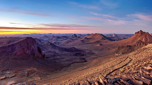 Vast desert landscape at sunset with mountain ranges on the horizon, The landscape of the Ahaggar