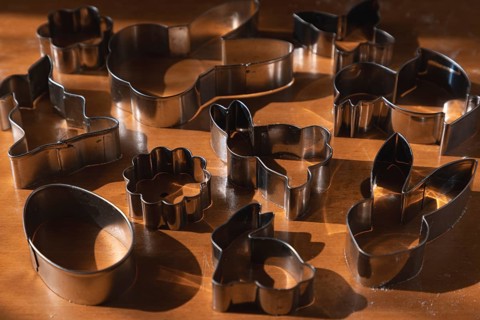 Different metal cookie cutters for Easter on a wooden surface