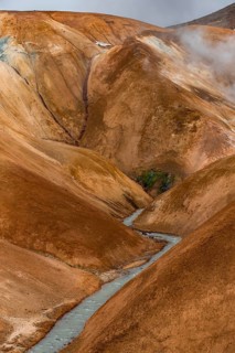 Steaming stream between colourful rhyolite mountains, Hveradalir geothermal area, Kerlingarfjöll,