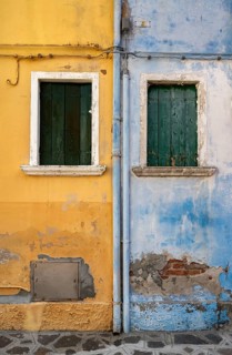 Blue and yellow house facade with windows, colourful houses on the island of Burano, Venice,