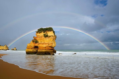 Rocks on beach with rainbow, Praia Dona Ana, Lagos, Algarve, Portugal