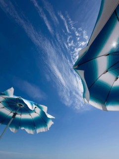 Parasols in front of a blue sky with clouds