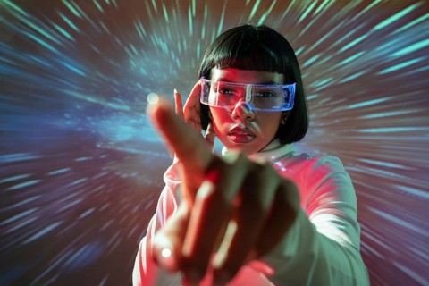 Latin woman interacts with an immersive virtual reality environment, wearing VR glasses. The scene