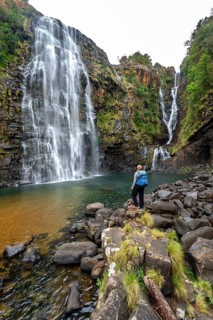 Young woman standing in front of a waterfall, Lisbon Falls, long exposure, near Graskop,