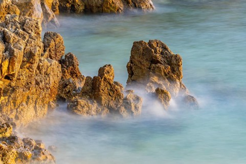 Crystal clear and turquoise water on the beach of Ustrine Bay on a sunny day at sunset on the