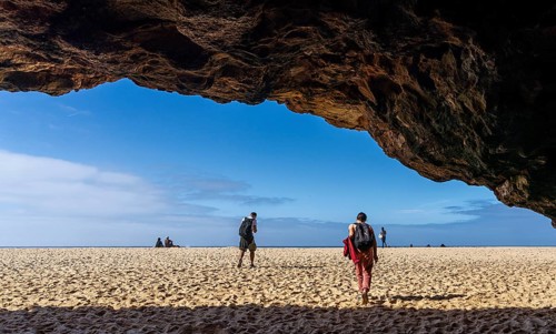 Tourists watch the waves of the Atlantic on the rocky plateau of Sito, also known as Forte São