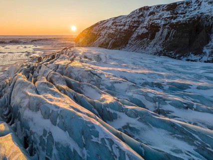Breathtaking beauty of Glacier in Skaftafell under a golden winter sunrise. The scene captures the