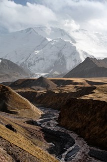 Achik Tash river, Achik Tash valley, behind glaciated and snow-covered mountain peak Pik Lenin,