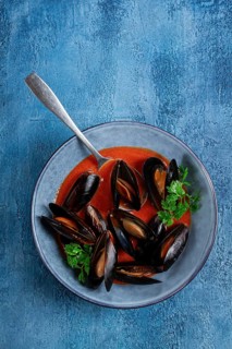 Fra Diavolo mussels, mussels in tomato sauce, Italian dish, on a blue background, homemade, no
