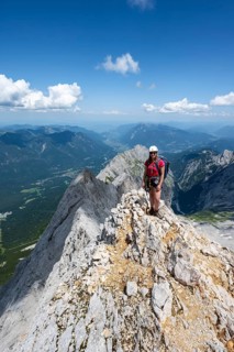 Mountaineer with helmet on a mountain ridge, ascent to the Zugspitze, Zugspitze via ferrata,