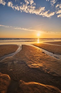 Atlantic ocean sunset with surging waves at Fonte da Telha beach, Costa da Caparica, Portugal