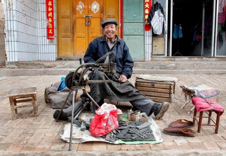Xining, CHN, 27.02.09 - portrait of a Chinese shoemaker. Portrait picture of a roadside cobbler in