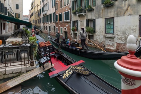 Gondola ride with tourists through the old town of Venice, Veneto, Italy