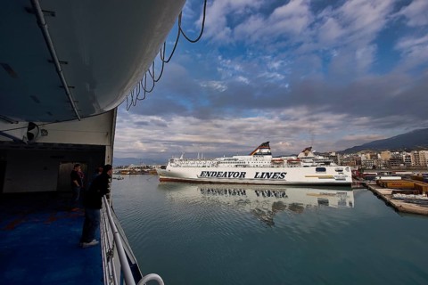 View from a ferry of the harbor with ships and dramatic clouds, Old ferry port in central Patras,