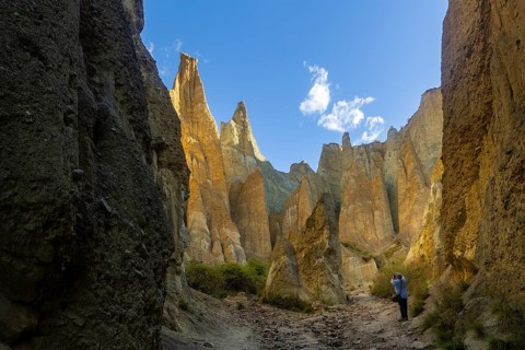 Back view of unrecognizable person exploring the dramatic Clay Cliffs in the Canterbury region of