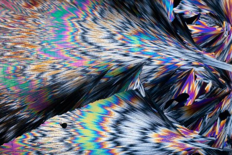 Striking, spectrum-like colors of hippuric acid crystals under a microscope. These colors range