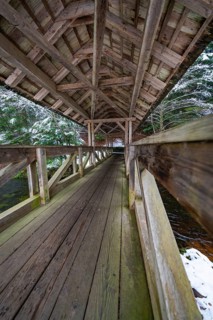 Interior view of a wooden bridge over a snow-covered forest path, Kälberbrücke, Enzklösterle, Calw