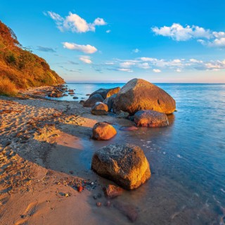 Coastal landscape with large boulders on the Baltic Sea beach in the evening light, Mönchgut Nature